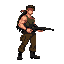 a pixel art sprite of a muscular, rambo-like soldier in side view. he has long black hair, a red bandana, a green tank top, brown pants, and black boots. he is holding a large black machine gun, aimin